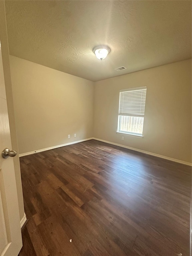 8239 Polaris Point Ln, Cypress, TX 77433 - empty room featuring dark wood-style flooring, baseboards, and a textured ceiling