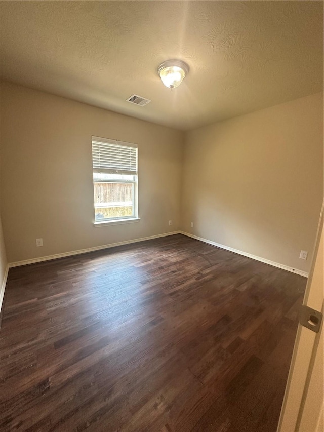 8239 Polaris Point Ln, Cypress, TX 77433 - unfurnished room with dark wood-style flooring, baseboards, and a textured ceiling