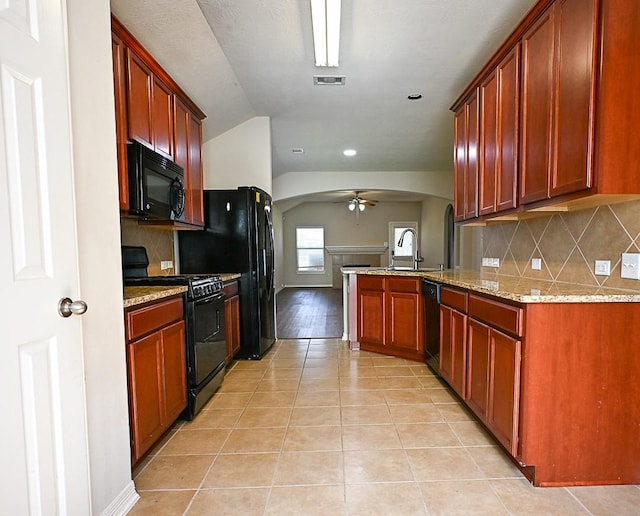 8239 Polaris Point Ln, Cypress, TX 77433 - kitchen featuring black appliances, arched walkways, vaulted ceiling, a peninsula, and light stone counters