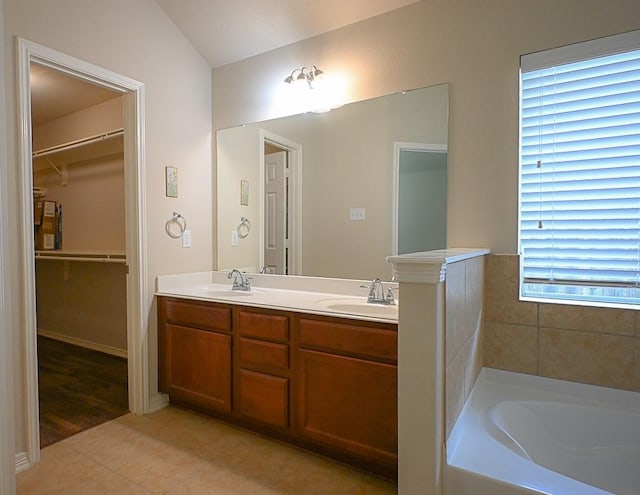 8239 Polaris Point Ln, Cypress, TX 77433 - bathroom featuring double vanity, tile patterned flooring, a tub to relax in, a walk in closet, and lofted ceiling