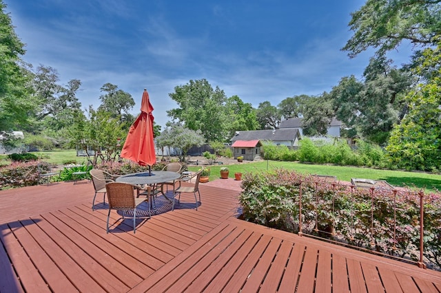1026 Atchison St, Sealy, TX 77474 - wooden terrace featuring a lawn, outdoor dining space, and view of scattered trees