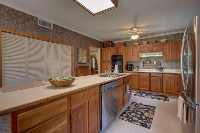1026 Atchison St, Sealy, TX 77474 - kitchen with appliances with stainless steel finishes, under cabinet range hood, wallpapered walls, light countertops, and ceiling fan