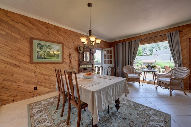 1026 Atchison St, Sealy, TX 77474 - dining room with a chandelier, wood walls, healthy amount of natural light, light tile patterned floors, and crown molding