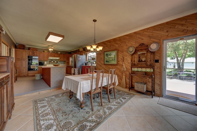1026 Atchison St, Sealy, TX 77474 - dining area featuring wood walls, a chandelier, healthy amount of natural light, light tile patterned floors, and crown molding