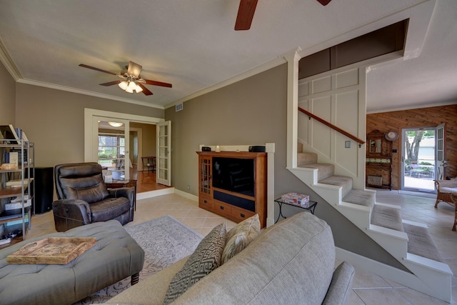 1026 Atchison St, Sealy, TX 77474 - tiled living room with a ceiling fan, plenty of natural light, stairs, ornamental molding, and wood walls