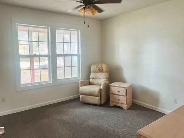 9401 Montgomery Ln, La Porte, TX 77571 - sitting room featuring ceiling fan, healthy amount of natural light, dark carpet, and baseboards