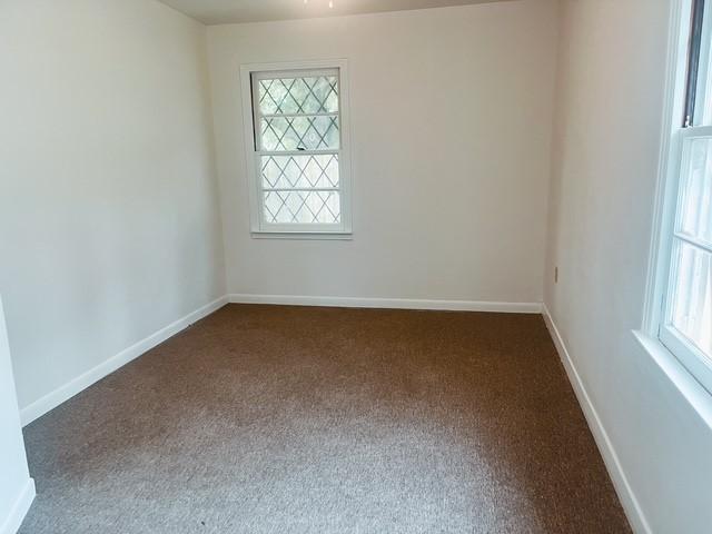 9401 Montgomery Ln, La Porte, TX 77571 - spare room with dark colored carpet, plenty of natural light, and baseboards