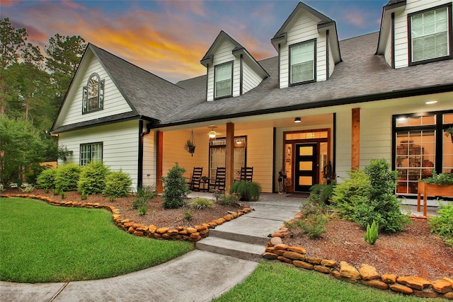 11698 Creek View Ln, Conroe, TX 77385 - cape cod home featuring a porch, a front yard, and roof with shingles