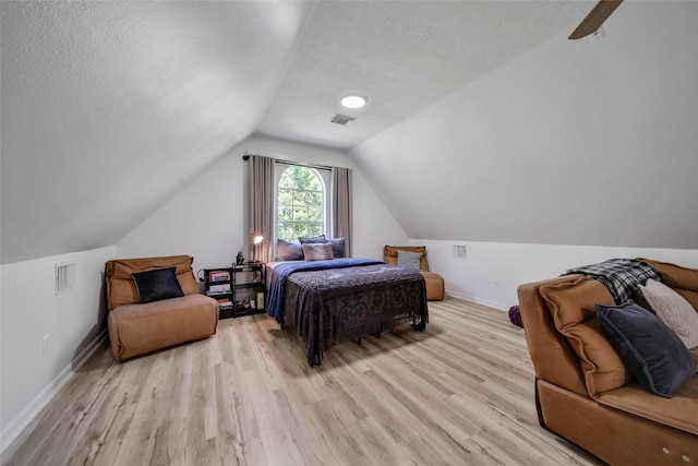 11698 Creek View Ln, Conroe, TX 77385 - bedroom with light wood-type flooring, vaulted ceiling, baseboards, and a textured ceiling
