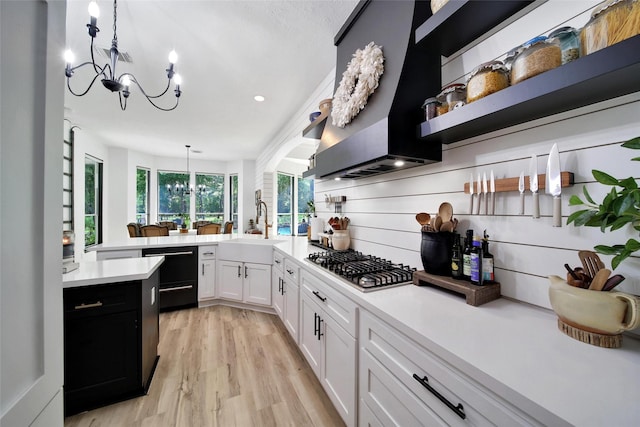11698 Creek View Ln, Conroe, TX 77385 - kitchen featuring wall chimney exhaust hood, stainless steel gas cooktop, a sink, a chandelier, and recessed lighting