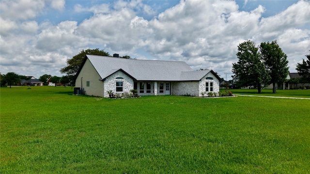 9035 N Point Dr, Beach City, TX 77523 - view of front of property featuring stone siding, cooling unit, and a front lawn