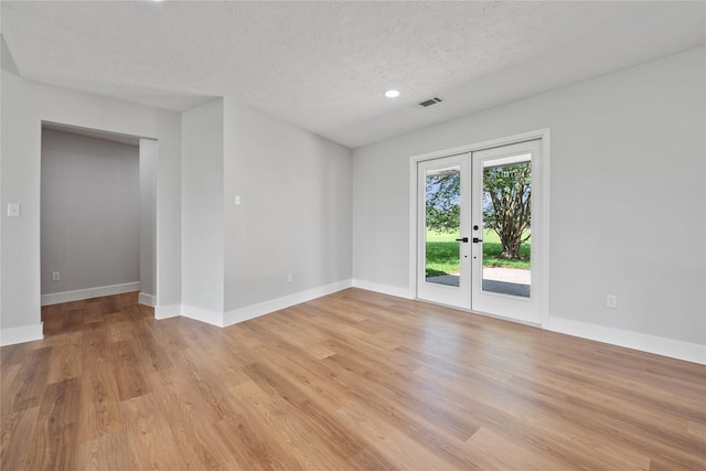 9035 N Point Dr, Beach City, TX 77523 - unfurnished room with french doors, light wood-type flooring, baseboards, a textured ceiling, and recessed lighting