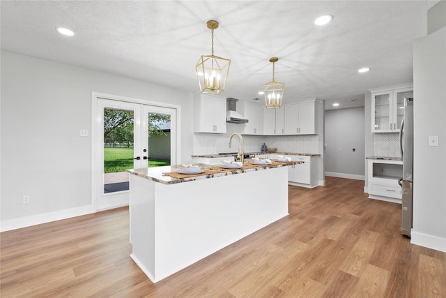 9035 N Point Dr, Beach City, TX 77523 - kitchen featuring tasteful backsplash, freestanding refrigerator, recessed lighting, wall chimney exhaust hood, and light wood-type flooring