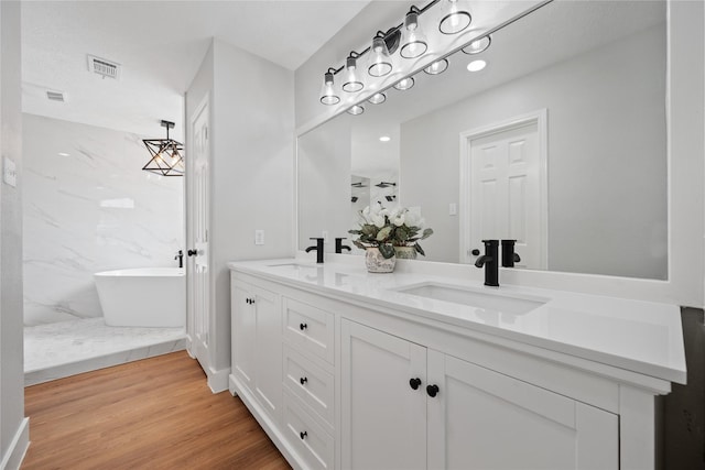 9035 N Point Dr, Beach City, TX 77523 - full bath with double vanity, a freestanding bath, and wood finished floors