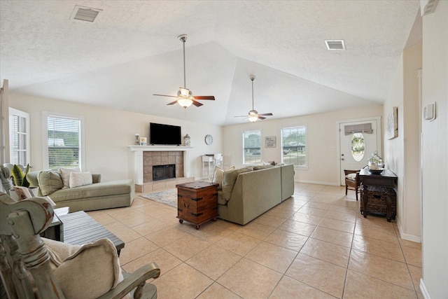 115 N River Place Rd, Rio Frio, TX 78879 - living area featuring a fireplace, plenty of natural light, a ceiling fan, light tile patterned floors, and a textured ceiling