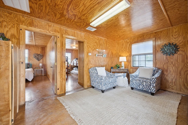 115 N River Place Rd, Rio Frio, TX 78879 - sitting room featuring wood walls, wooden ceiling, and concrete floors