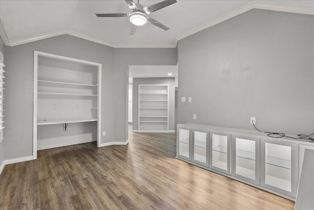 16610 Avenfield Rd, Tomball, TX 77377 - unfurnished living room featuring vaulted ceiling, built in features, wood finished floors, ceiling fan, and crown molding