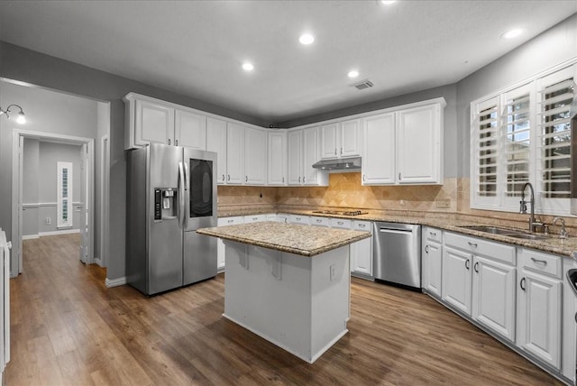 16610 Avenfield Rd, Tomball, TX 77377 - kitchen with stainless steel appliances, white cabinets, a center island, decorative backsplash, and dark wood-type flooring