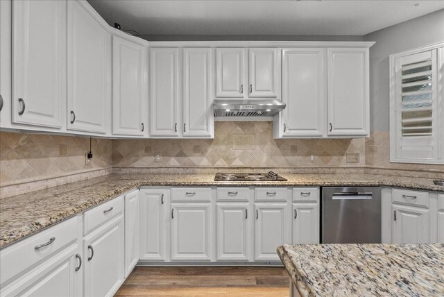 16610 Avenfield Rd, Tomball, TX 77377 - kitchen featuring appliances with stainless steel finishes, under cabinet range hood, white cabinetry, and light stone countertops