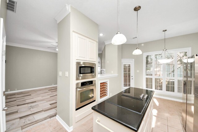 12819 Kingsbridge Ln, Houston, TX 77077 - kitchen with stainless steel appliances, white cabinets, a center island, ceiling fan, and decorative light fixtures