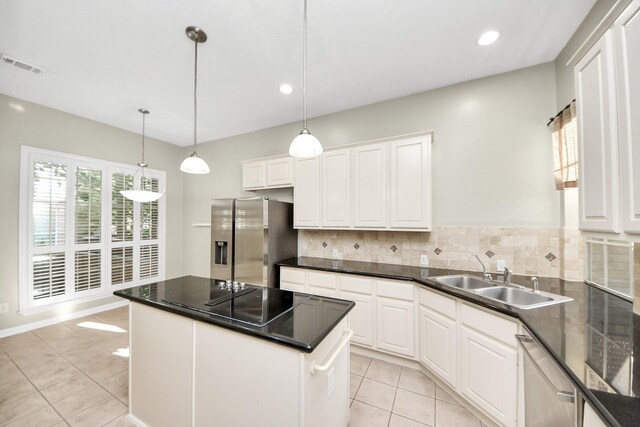 12819 Kingsbridge Ln, Houston, TX 77077 - kitchen featuring stainless steel appliances, a sink, light tile patterned floors, backsplash, and white cabinets
