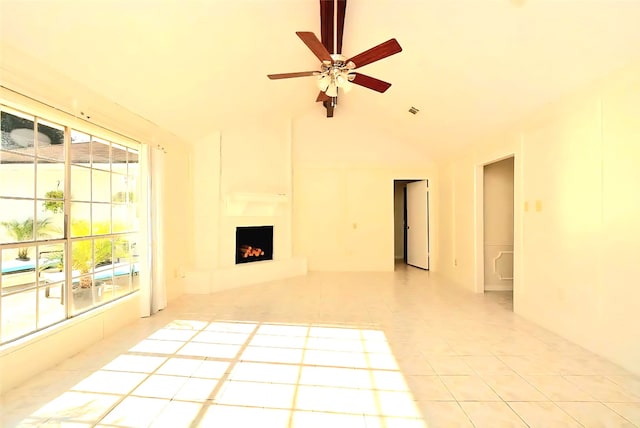 839 Hidden Canyon Rd, Katy, TX 77450 - unfurnished living room featuring healthy amount of natural light, light tile patterned floors, ceiling fan, a fireplace with raised hearth, and vaulted ceiling