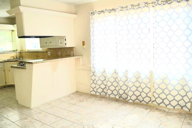 839 Hidden Canyon Rd, Katy, TX 77450 - kitchen featuring a sink, a peninsula, tasteful backsplash, and light tile patterned floors