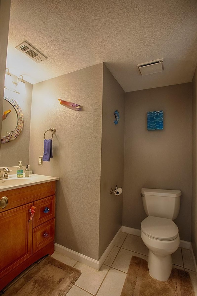 907 Davis Rd, League City, TX 77573 - half bath with vanity, toilet, a textured ceiling, and tile patterned flooring