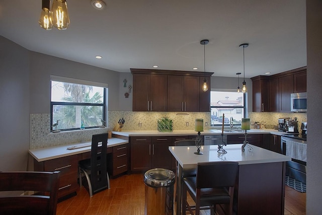907 Davis Rd, League City, TX 77573 - kitchen with stainless steel appliances, light countertops, dark wood-type flooring, a center island, and tasteful backsplash