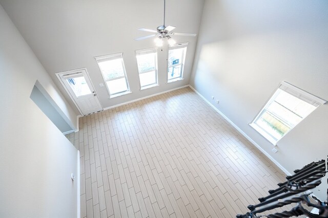32322 Dusted Bronze Dr, Brookshire, TX 77423 - unfurnished living room featuring a ceiling fan, baseboards, and a high ceiling