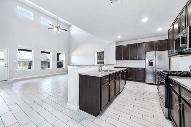 32322 Dusted Bronze Dr, Brookshire, TX 77423 - kitchen with stainless steel appliances, a ceiling fan, a sink, backsplash, and dark brown cabinetry