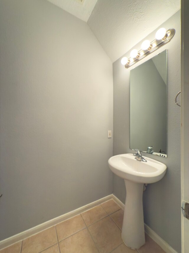 5227 Brinkman Ct, Houston, TX 77091 - bathroom with vaulted ceiling, tile patterned flooring, baseboards, and a sink
