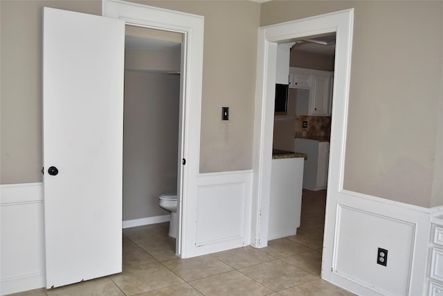 18318 Ella Blvd, Spring, TX 77388 - bathroom featuring a wainscoted wall, tile patterned flooring, and toilet
