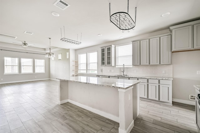 350 Selah Ct, Alvin, TX 77511 - kitchen with a ceiling fan, a center island, gray cabinetry, plenty of natural light, and recessed lighting