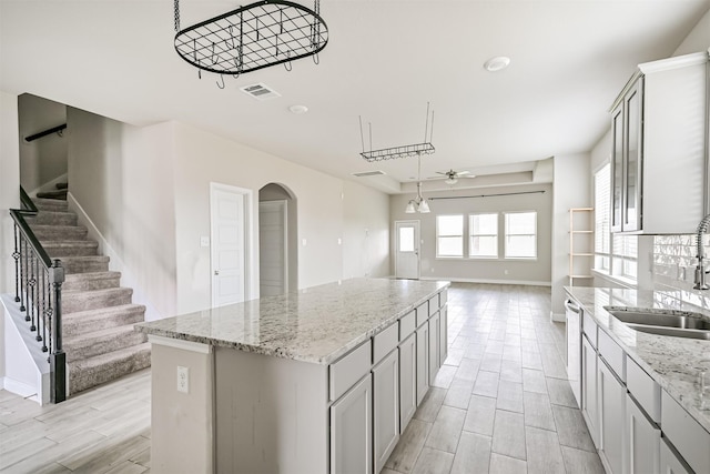 350 Selah Ct, Alvin, TX 77511 - kitchen with a ceiling fan, a center island, wood tiled floors, open floor plan, and arched walkways