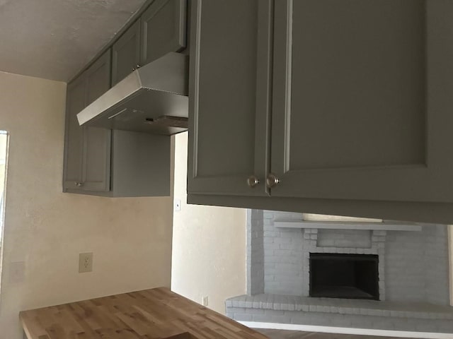 6322 Purple Sage Rd, Houston, TX 77049 - detailed view of under cabinet range hood, wood finished floors, and a fireplace