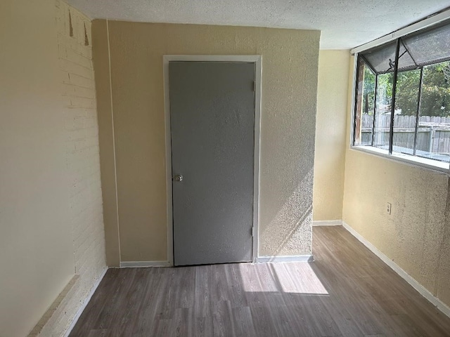 6322 Purple Sage Rd, Houston, TX 77049 - unfurnished room with a textured wall, wood finished floors, and baseboards