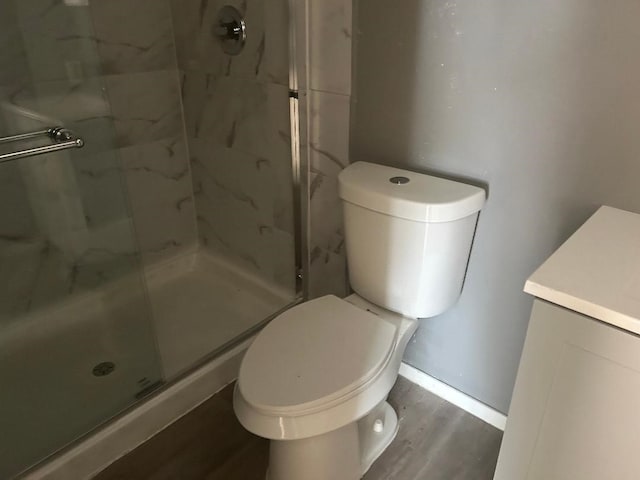 6322 Purple Sage Rd, Houston, TX 77049 - bathroom with a marble finish shower, wood finished floors, toilet, vanity, and baseboards