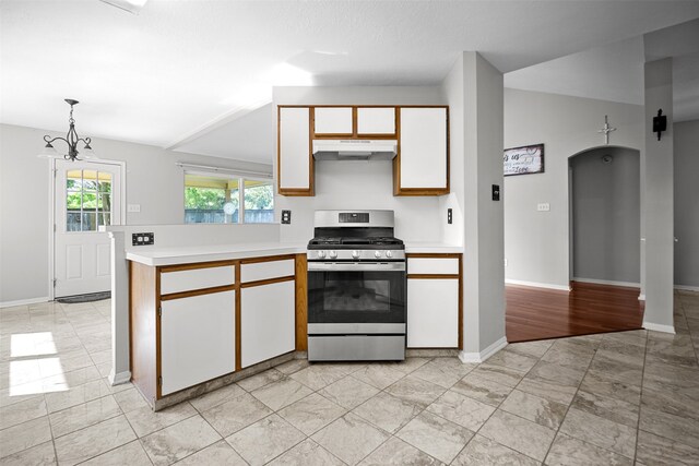 1726 Havelock Dr, Spring, TX 77386 - kitchen featuring stainless steel range with gas cooktop, under cabinet range hood, light countertops, arched walkways, and a peninsula