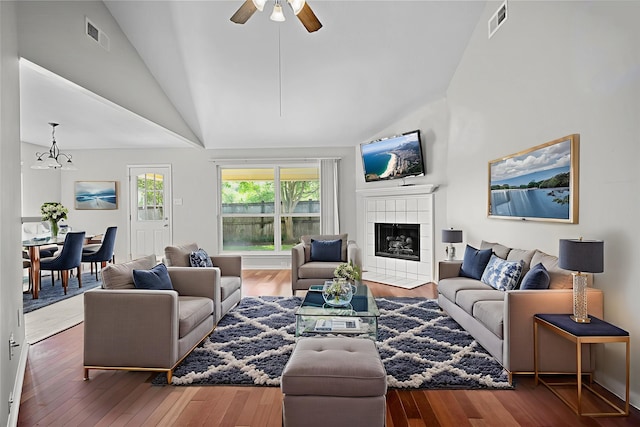 1726 Havelock Dr, Spring, TX 77386 - living room with a tile fireplace, a chandelier, a ceiling fan, wood finished floors, and high vaulted ceiling