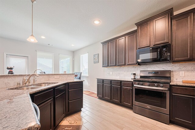 4507 Shallow Hill Ct, Houston, TX 77084 - kitchen with stainless steel range with gas stovetop, black microwave, a sink, backsplash, and dark brown cabinets