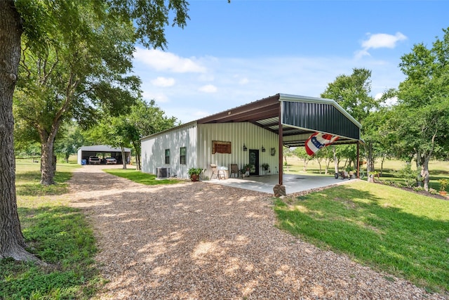 6448 Fm 2nd Rd, Navasota, TX 77868 - view of front of home with board and batten siding, central AC, a front yard, and an outbuilding