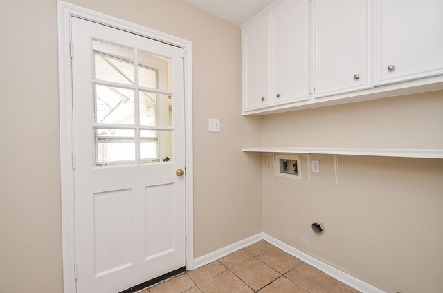 11703 Easterling Dr, Houston, TX 77065 - laundry room with electric dryer hookup, cabinet space, baseboards, washer hookup, and light tile patterned floors