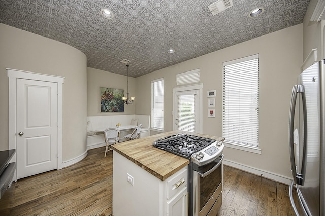 1239 W 22nd St Unit C, Houston, TX 77008 - kitchen featuring appliances with stainless steel finishes, butcher block counters, dark wood-type flooring, a chandelier, and white cabinetry