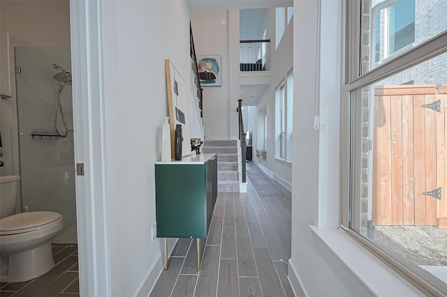 11251 Buchanan Coves Ln, Cypress, TX 77433 - hallway featuring wood tiled floors, a high ceiling, baseboards, and stairs