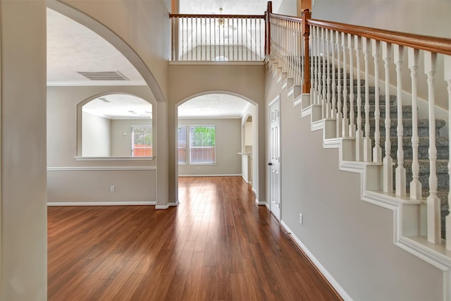 7818 Desert Canyon Ct, Houston, TX 77041 - foyer with dark wood-style floors, arched walkways, baseboards, and ornamental molding