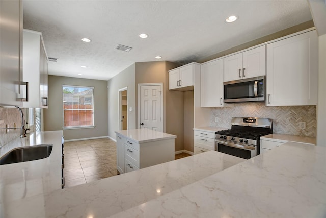 7818 Desert Canyon Ct, Houston, TX 77041 - kitchen featuring stainless steel appliances, a sink, backsplash, light stone counters, and recessed lighting