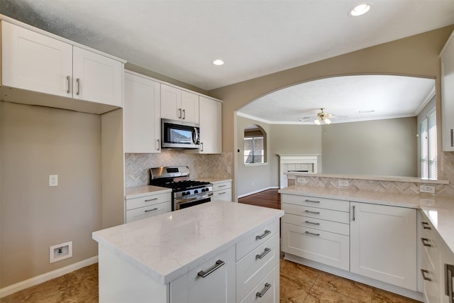 7818 Desert Canyon Ct, Houston, TX 77041 - kitchen with stainless steel appliances, arched walkways, a ceiling fan, tasteful backsplash, and healthy amount of natural light