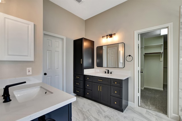 7818 Desert Canyon Ct, Houston, TX 77041 - full bathroom with two vanities, marble finish flooring, a walk in closet, and baseboards
