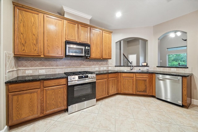 18411 S Raven Shore Dr, Cypress, TX 77433 - kitchen featuring appliances with stainless steel finishes, decorative backsplash, brown cabinetry, and recessed lighting
